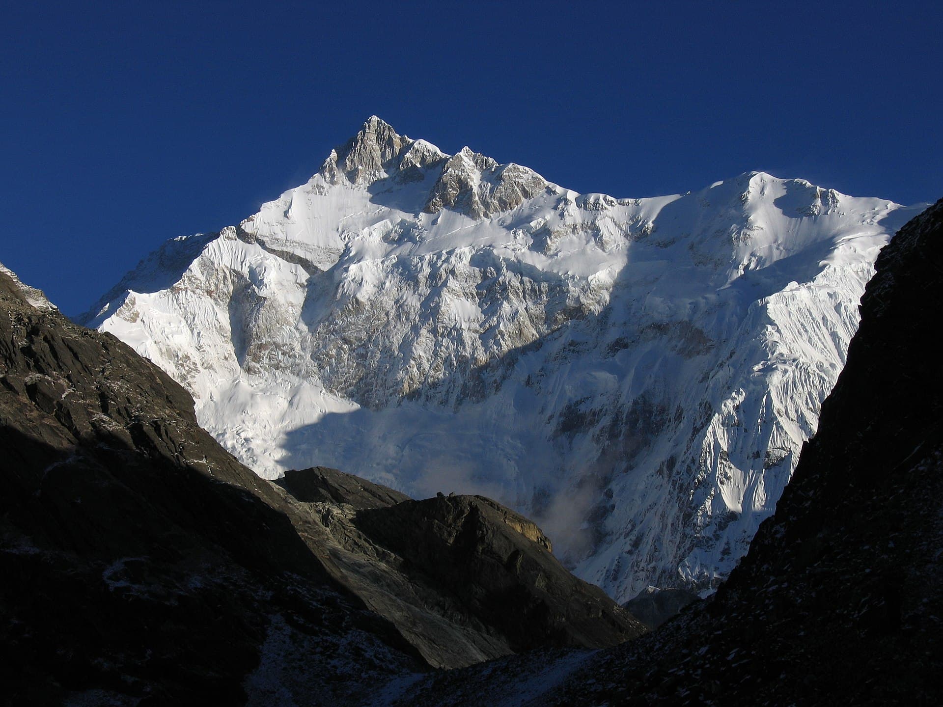 Picture of Kangchenjunga taken by author from Goecha La pass, 4940m, Sikkim. The peak in the image is actually the South peak of Kangchenjunga, which is about 400 ft lower than the main peak. You can also see the West peak of Kangchenjunga (Yalung Kang) as the round peak slightly to the left of the South Ridge (the ridge going left from the South peak).